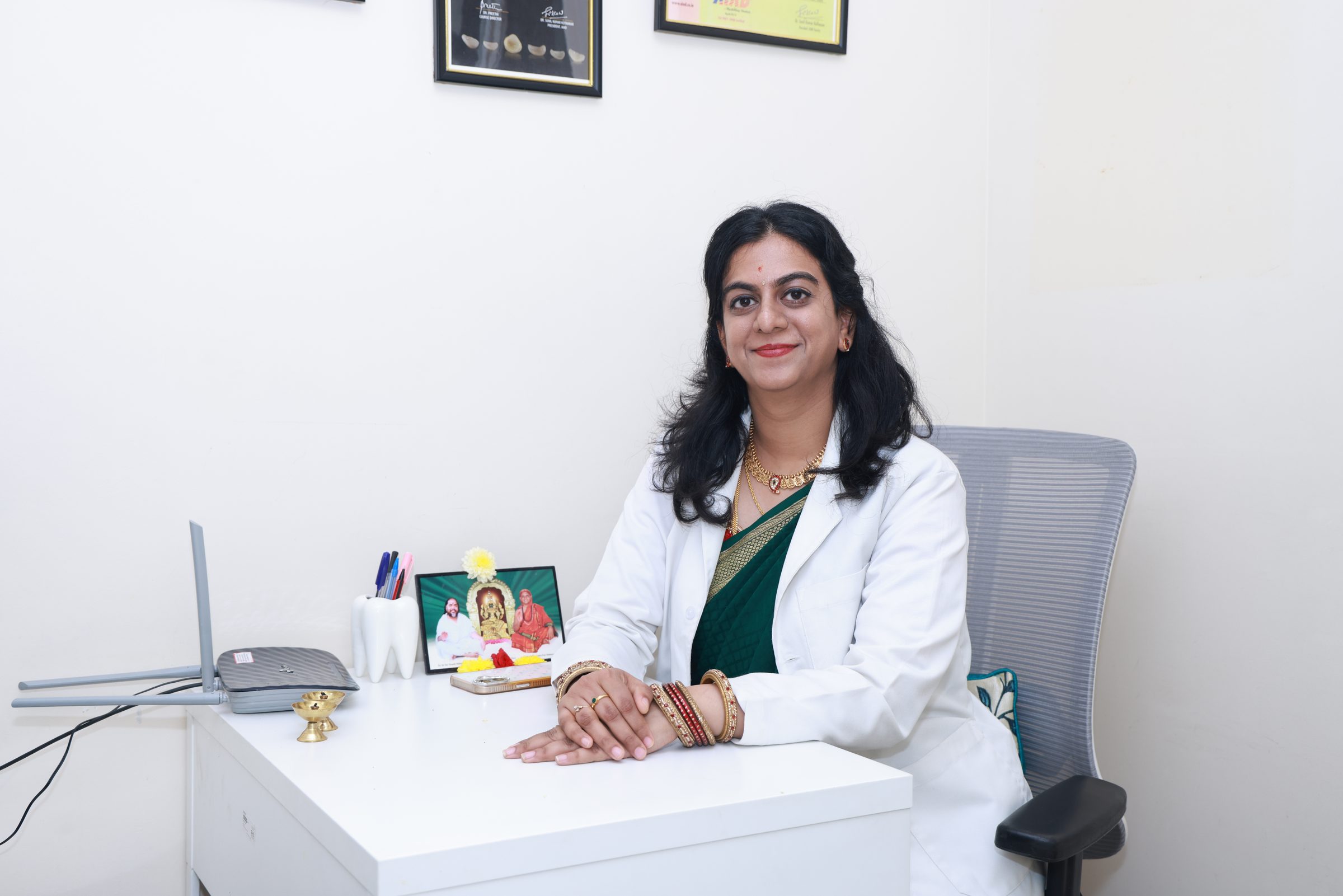 Dr. Sushmitha seated at her desk at Smithara Dental Care